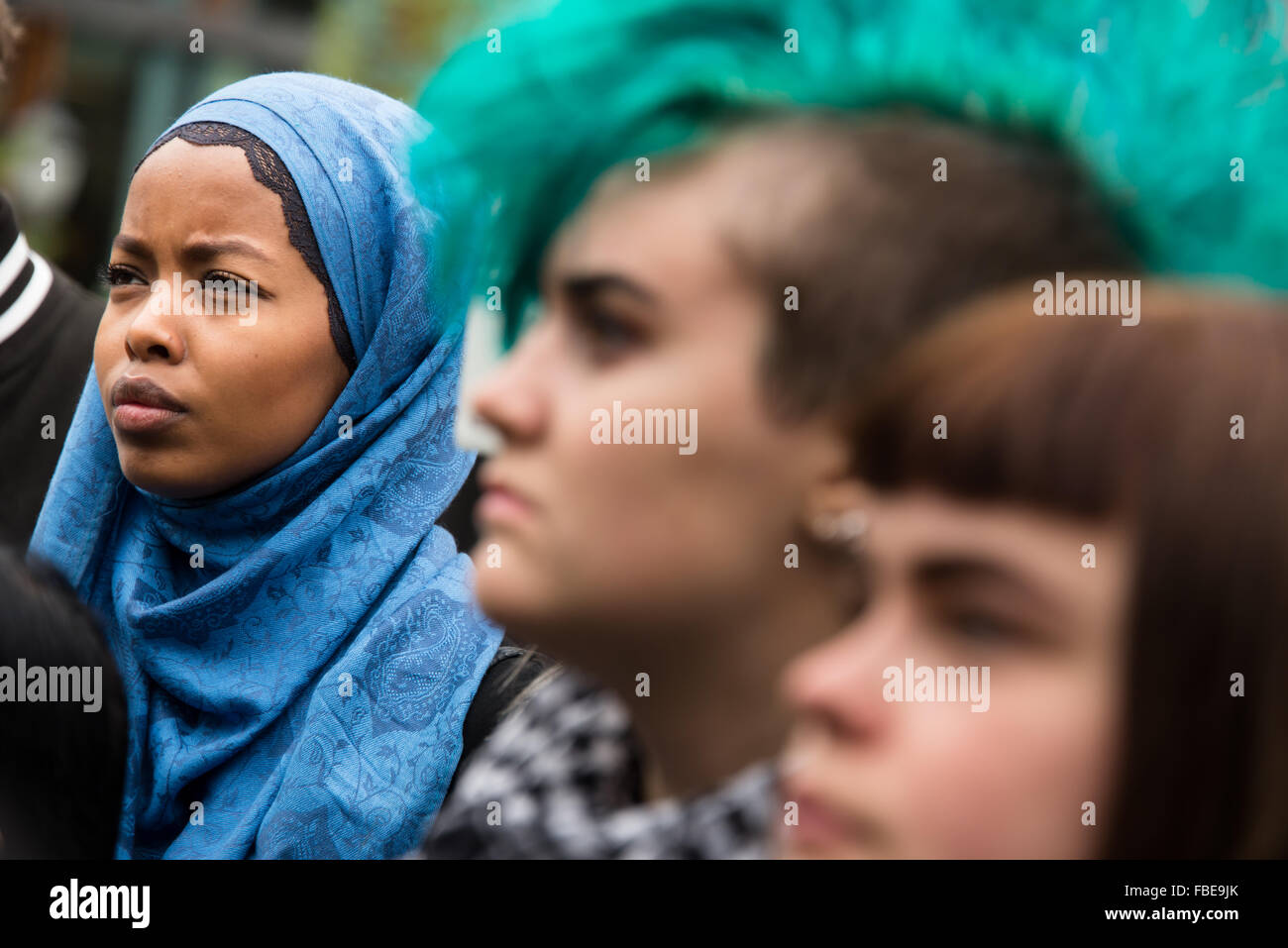 Una donna musulmana che indossa un hijab Velo sorge a fianco a fianco con un punk donna con una verde mohawk in un rally a sostegno dei rifugiati siriano di fronte all'edificio del parlamento a Oslo, Norvegia, settembre 12, 2015. Foto Stock