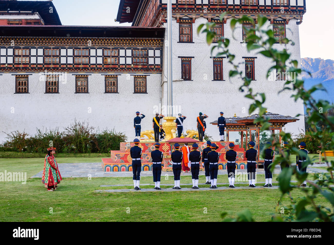 Il cerimoniale di abbassamento di bandiera al tramonto a Tashichho Dzong, sede del potere di governo bhutanese durante il crepuscolo, spazio di copia Foto Stock