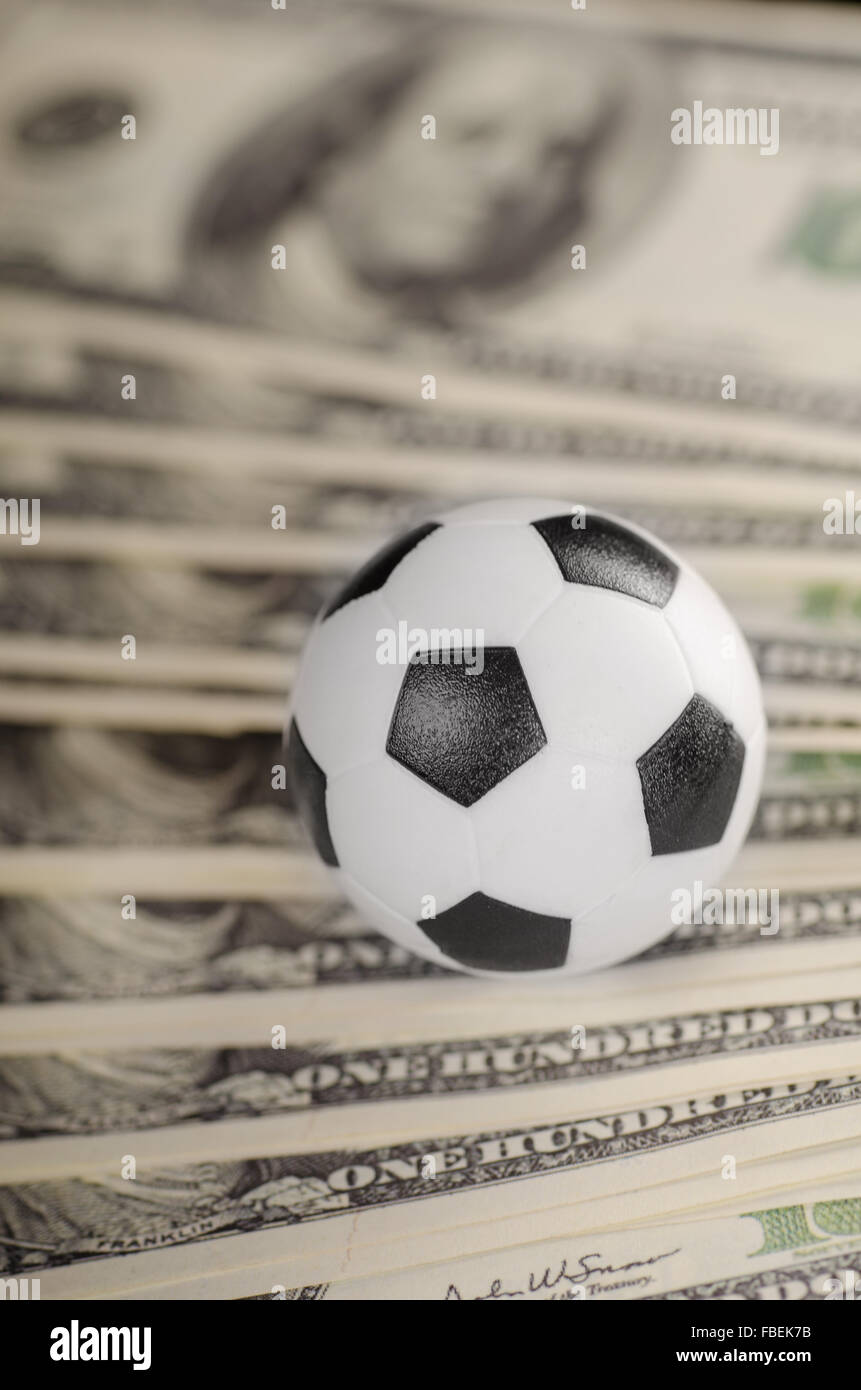 Pallone da calcio su sfondo di dollari Foto Stock