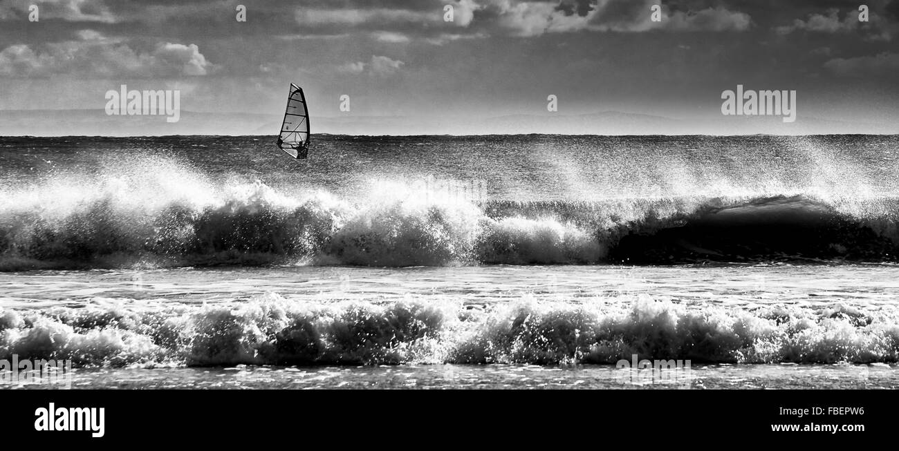 Wind surf a vela al di là di rompere il surf. Foto Stock
