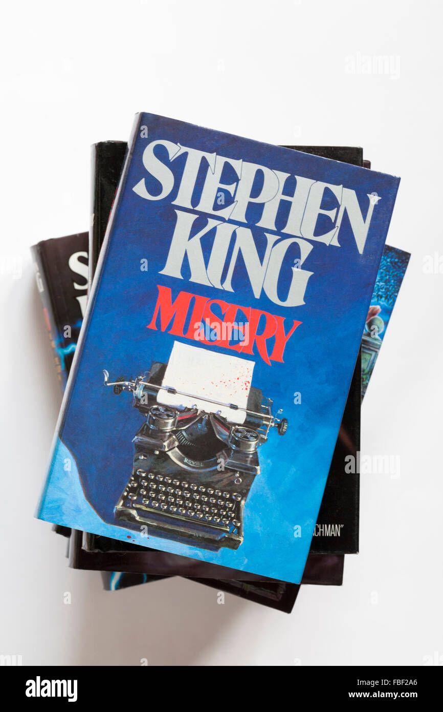 Pila di Stephen King libri con la miseria in cima isolata su sfondo bianco Foto Stock