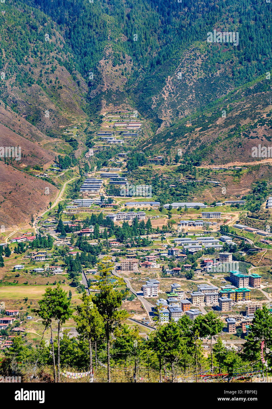 Vista di Thimphu capitale del Bhutan valle del Himalaya e la circostante foresta verde colline coperte di neve picchi con spazio di copia Foto Stock