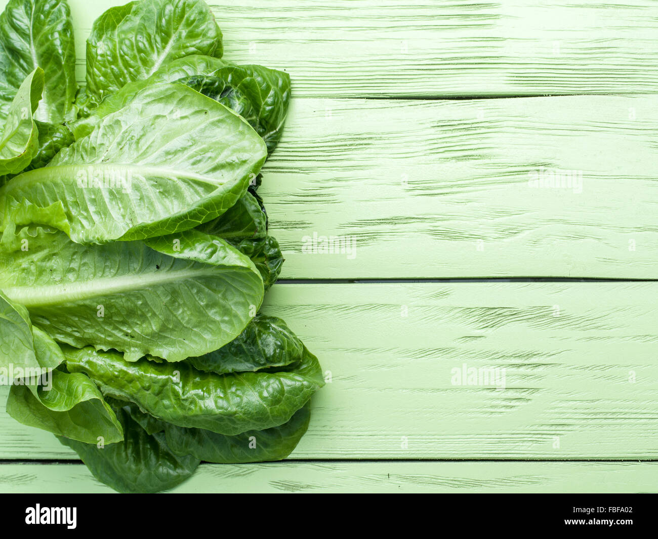 Su insalata verde sullo sfondo di legno. Foto Stock