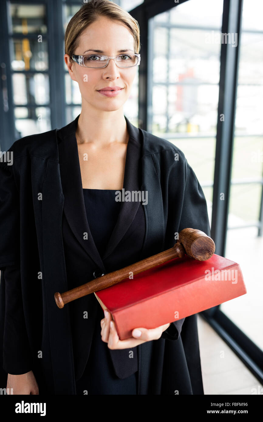 Avvocato femmina tenendo il suo libro e il suo martello Foto Stock