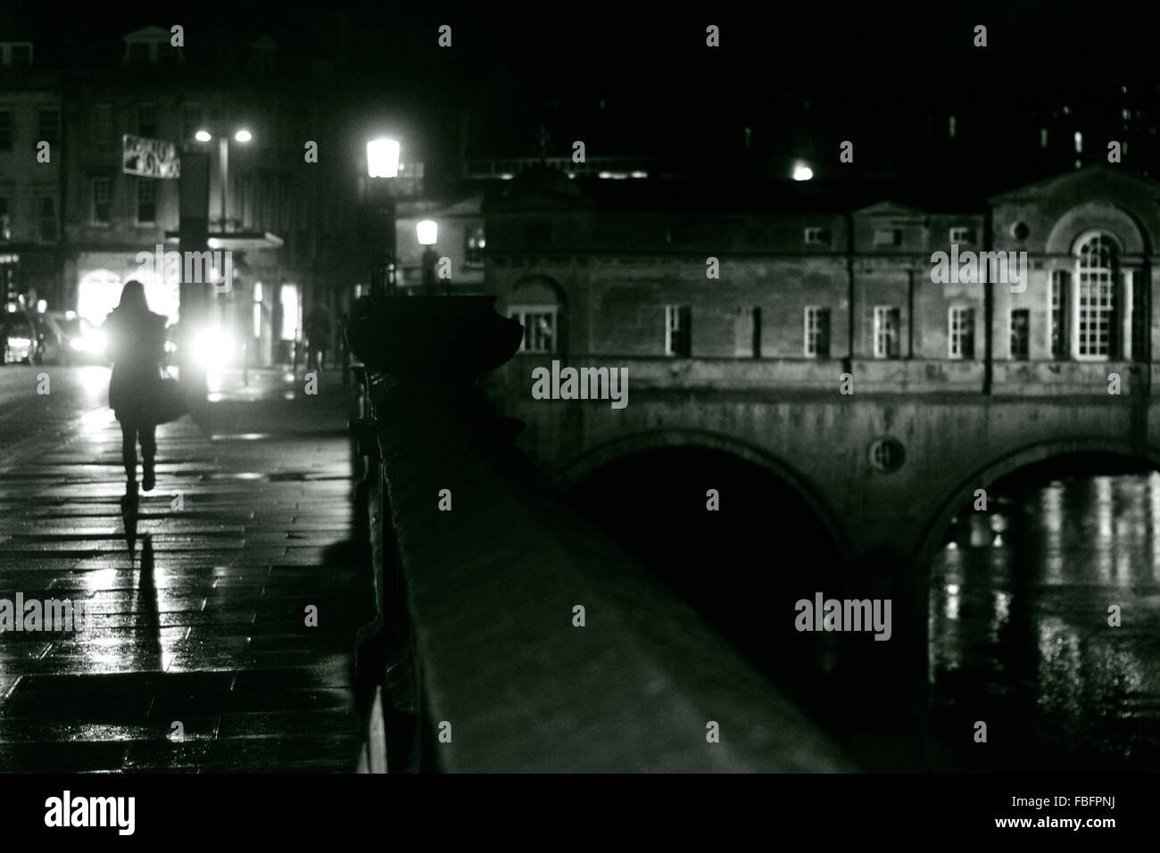 Donna che cammina nella vasca da bagno su una notte piovosa. Una signora da passeggiate Pulteney Bridge nel patrimonio mondiale UNESCO Città di Bath Foto Stock
