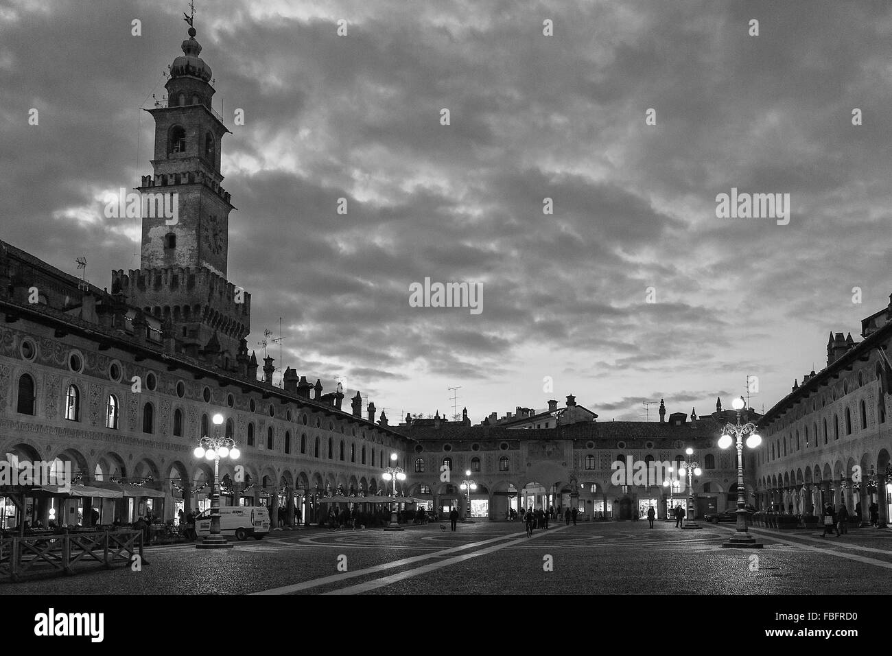 Bella nuvole nel cielo sopra la città torre quadrata circondata da vecchi lampioni in Italia durante il periodo invernale Foto Stock
