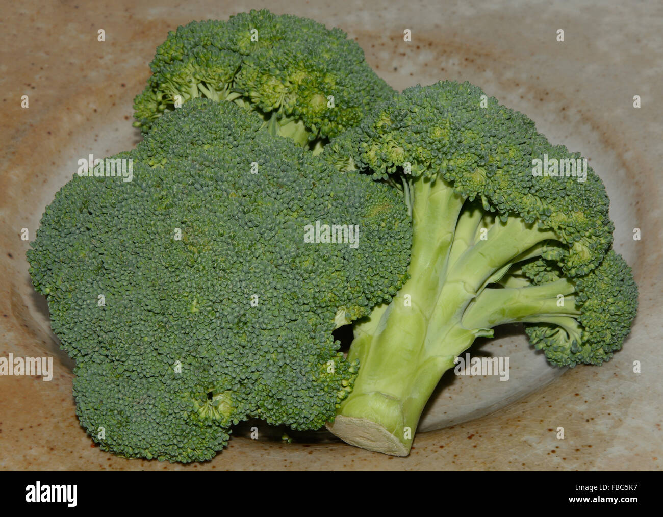 Tre grappoli di materie broccoli sulla piastra Foto Stock