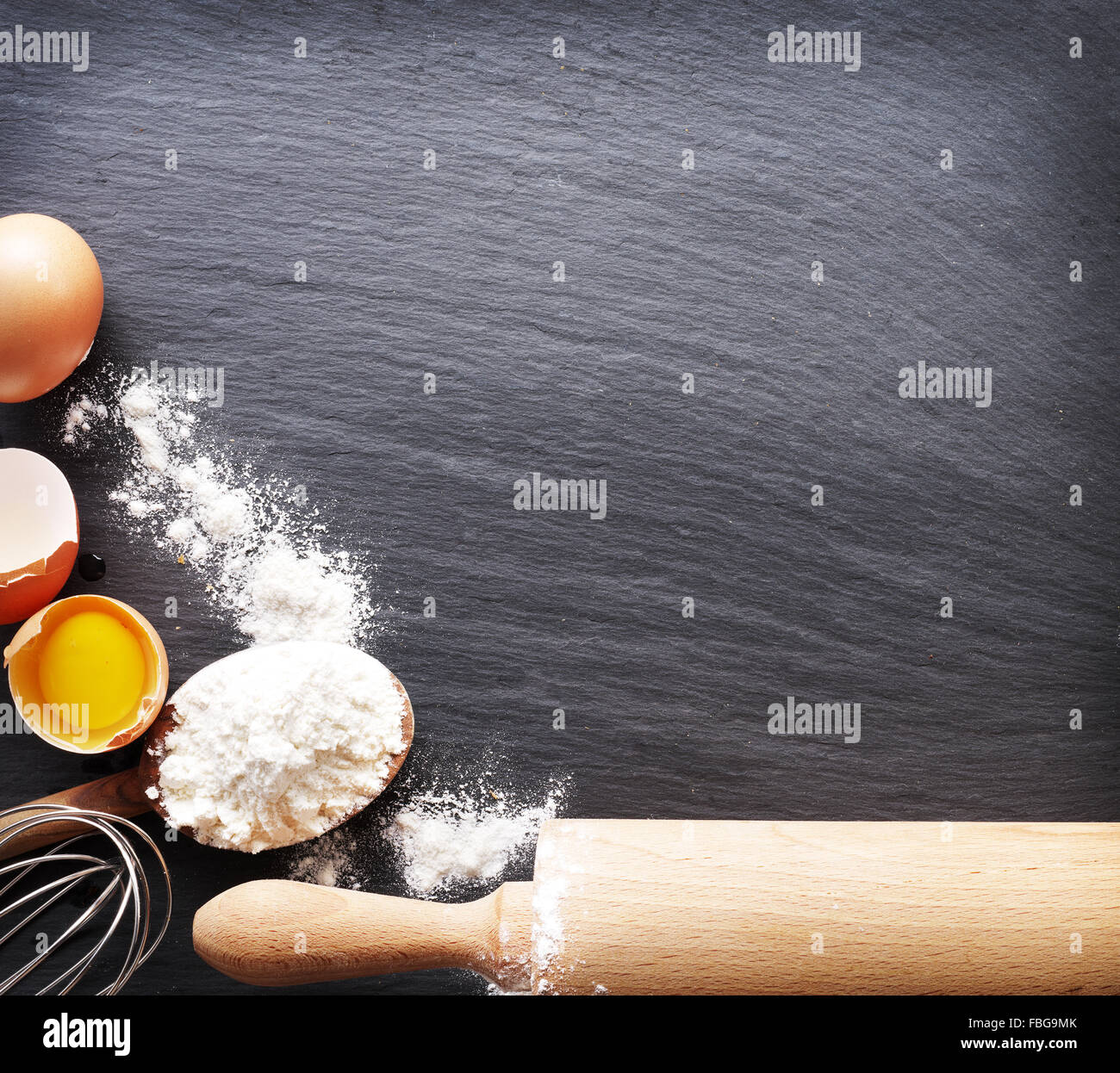 Preparazione di pasta. La cottura Ingredienti: uova e farina sul bordo nero. Foto Stock