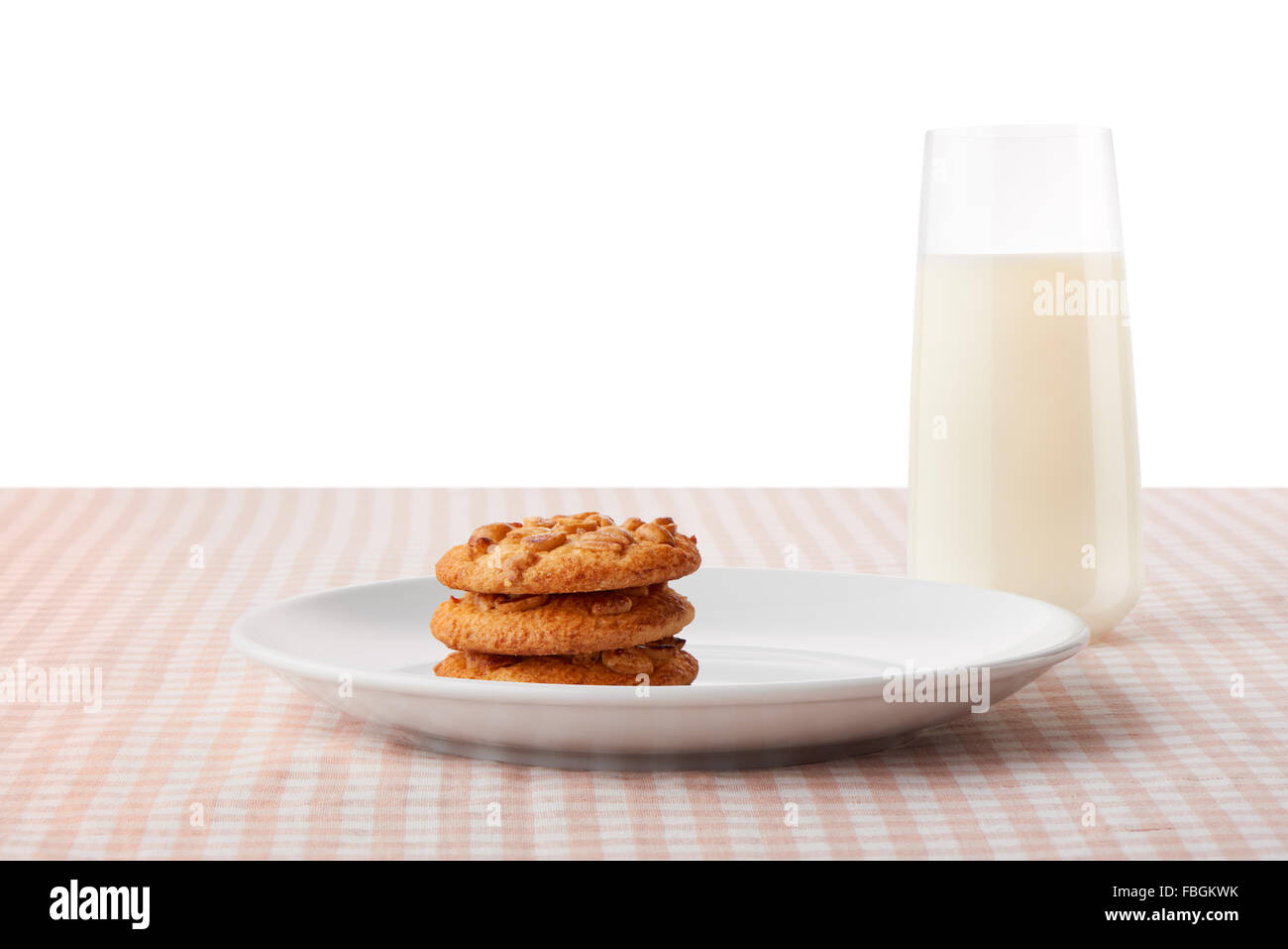 Pila di tre fatti in casa il burro di arachidi cookie sul bianco piastra in ceramica e vetro di latte sul classico tavolo a scacchi Foto Stock