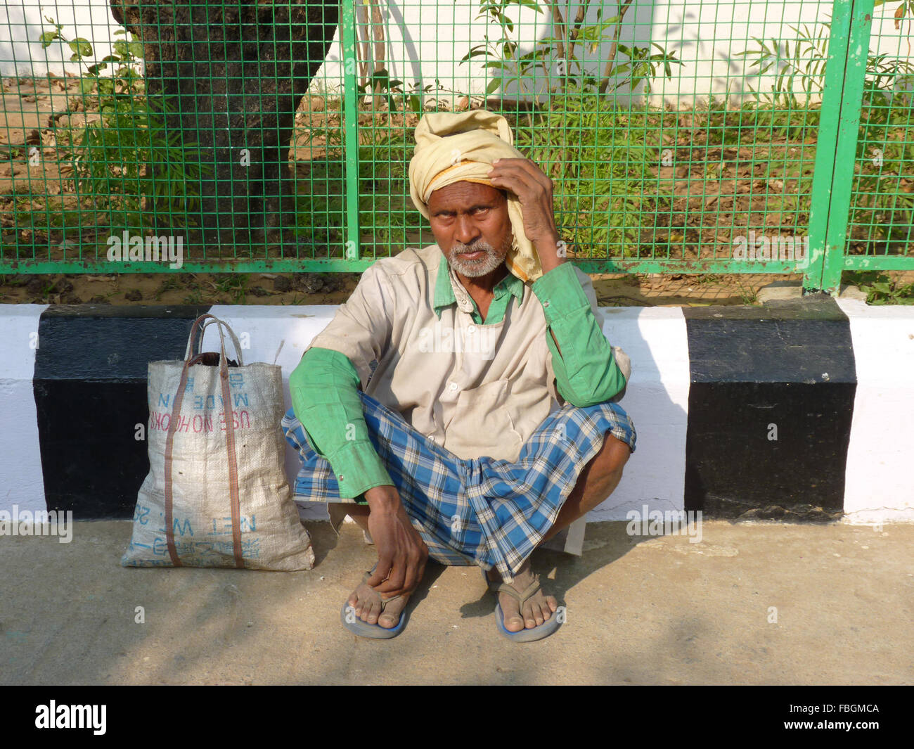 Un indiano Poor uomo seduto sulla strada Foto Stock