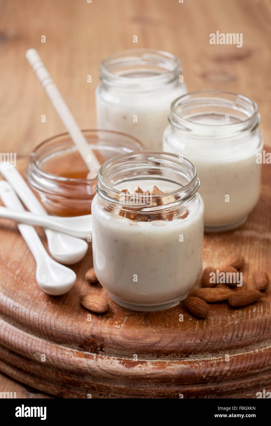 Yogurt fatto in casa latte di mandorla con farina di avena e miele su sfondo di legno Foto Stock