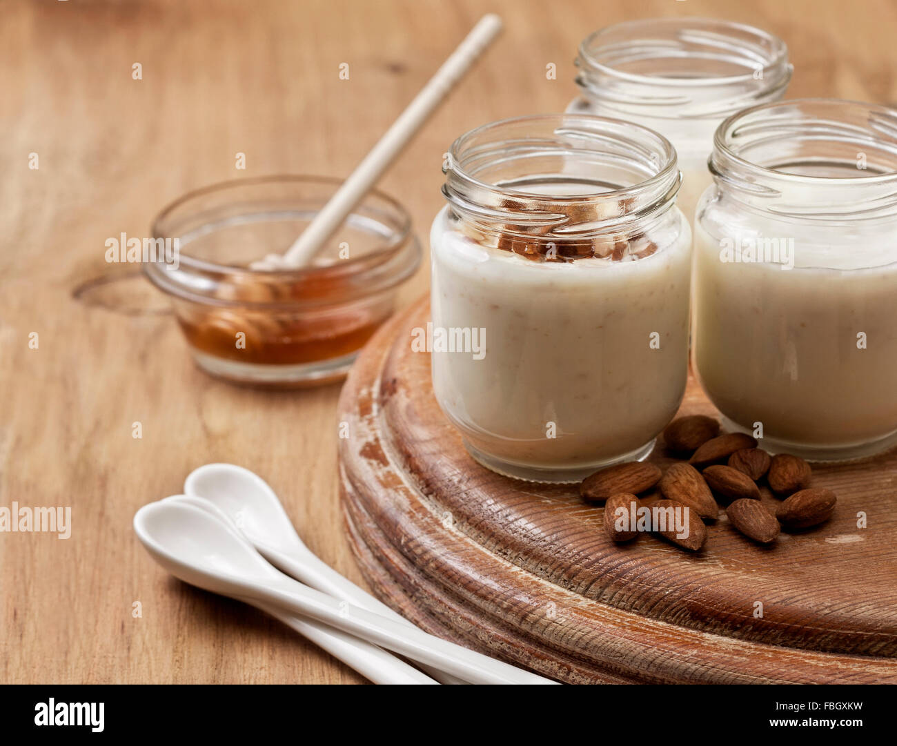 Yogurt fatto in casa latte di mandorla con farina di avena e miele su sfondo di legno Foto Stock