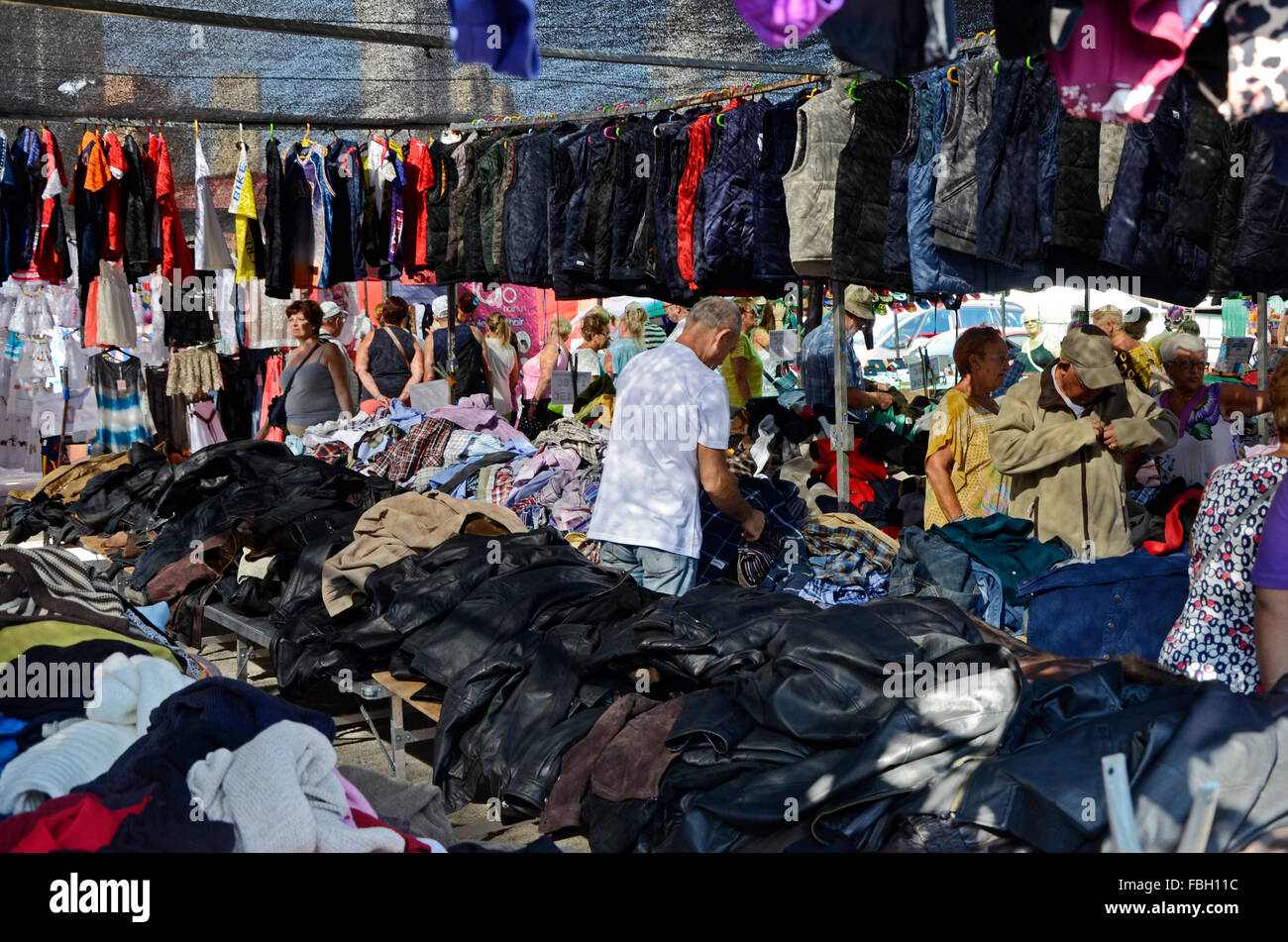Gli uomini e le donne scavare attraverso l offerta di un stand con vendita  abiti usati in un mercato a Benidorm, Alicante, Spagna Foto stock - Alamy