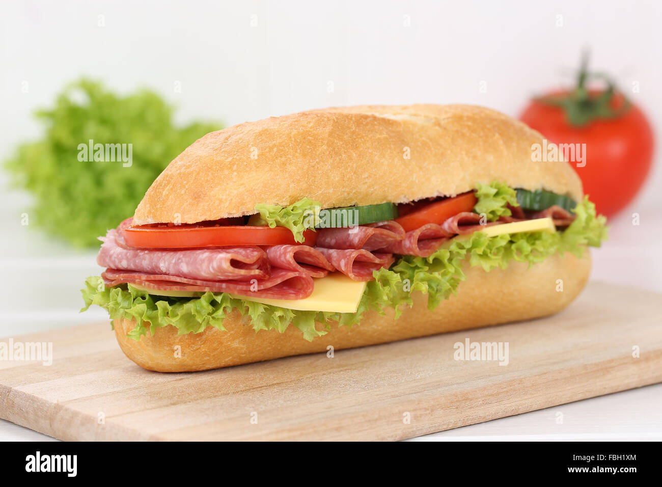 Sub deli sandwich baguette con salame prosciutto, formaggio, pomodori e lattuga per la prima colazione Foto Stock