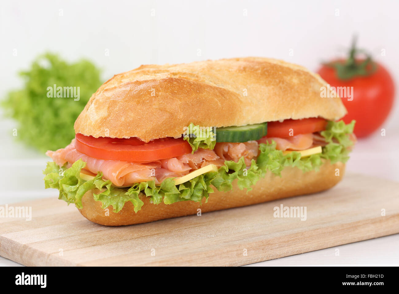 Sub deli sandwich baguette con salmone pesce, formaggio, pomodori e lattuga per la prima colazione Foto Stock