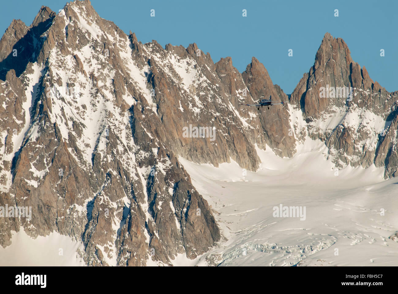 Unica luce di propulsori aeromobili battenti alto sopra la valle di Chamonix con picchi e un ghiacciaio sul massiccio del Monte Bianco nella parte posteriore Foto Stock