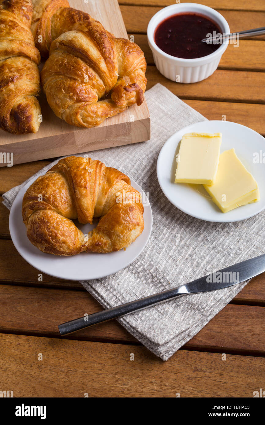 Croissant prima colazione con marmellata e burro Foto Stock