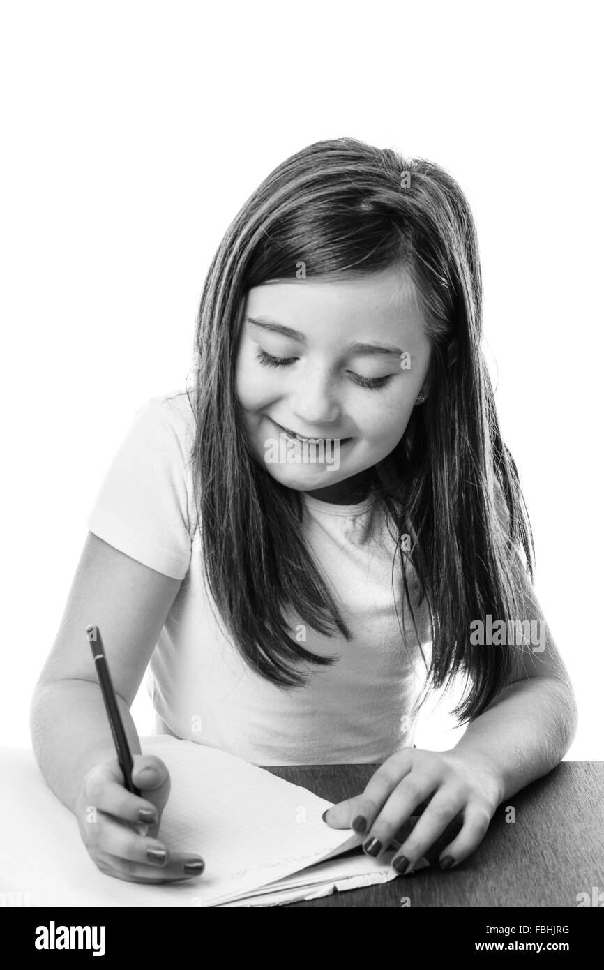 Ragazza giovane iscritto in un libro facendo il suo dovere Foto Stock