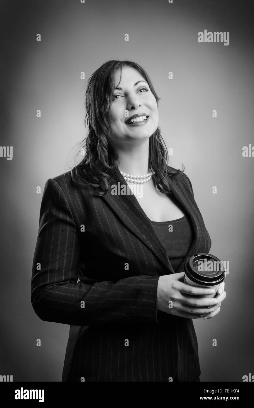 Business Woman è rilassante, tenendo il caffè da asporto Foto Stock