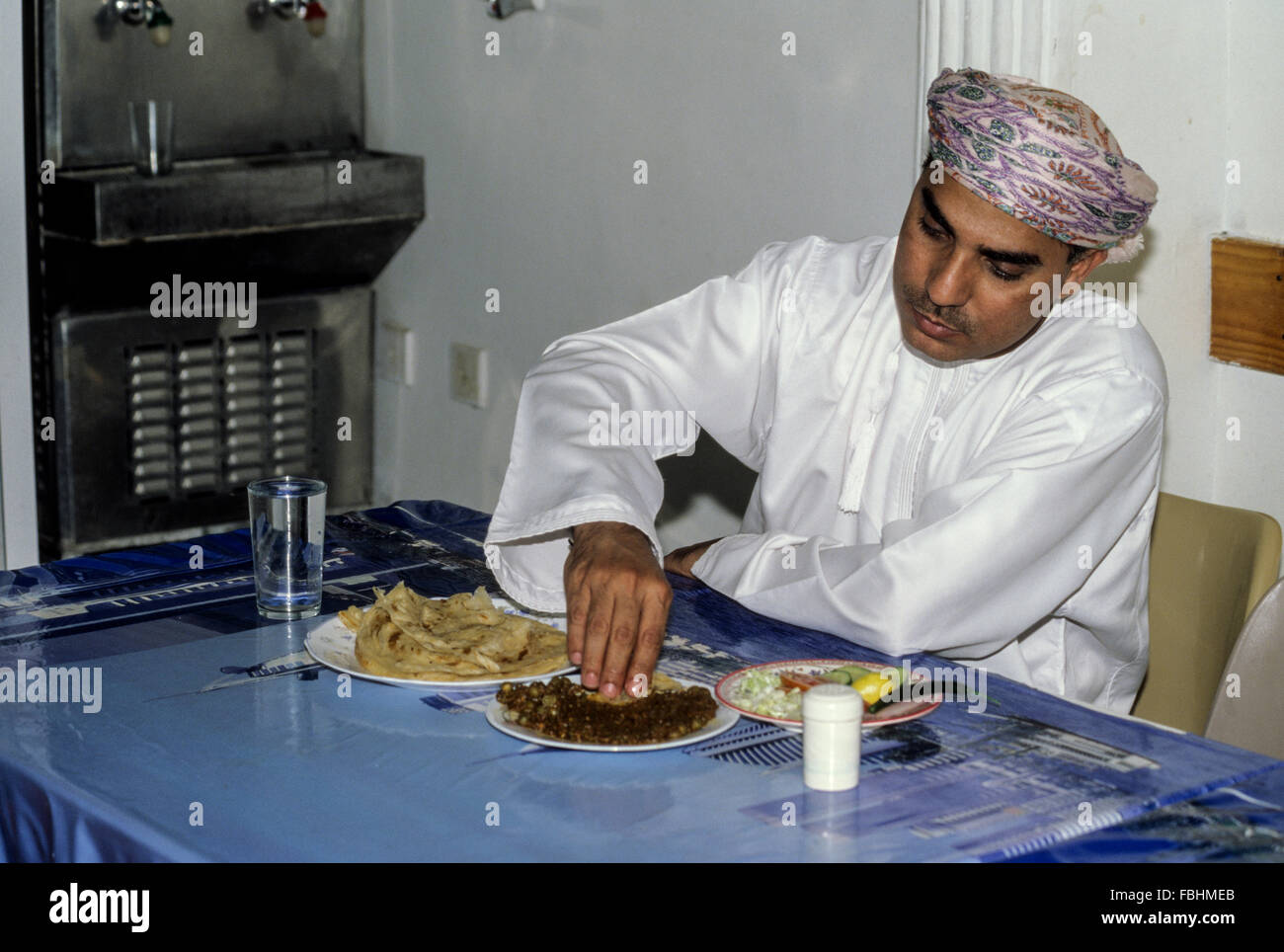 Nakhal, Oman. Omani Keema mangiare (carne, piselli, fagioli) con la sua mano. Foto Stock