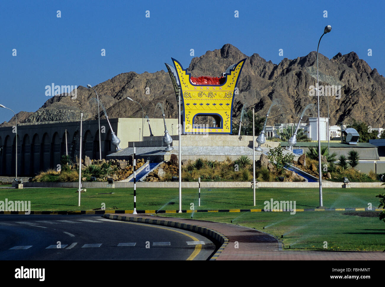 Muscat Oman. Majmar (bruciatore di incenso) la replica in una rotatoria. Spruzzi di acqua da repliche di rose-erogatori d'acqua. Foto Stock