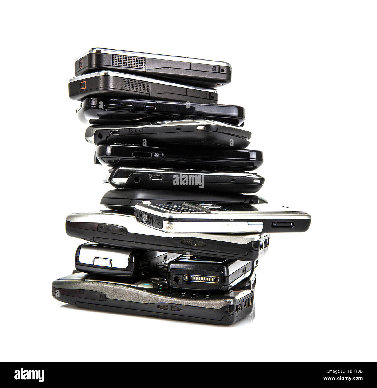 Pila di vecchi telefoni cellulari pronto per il riciclaggio su sfondo bianco Foto Stock