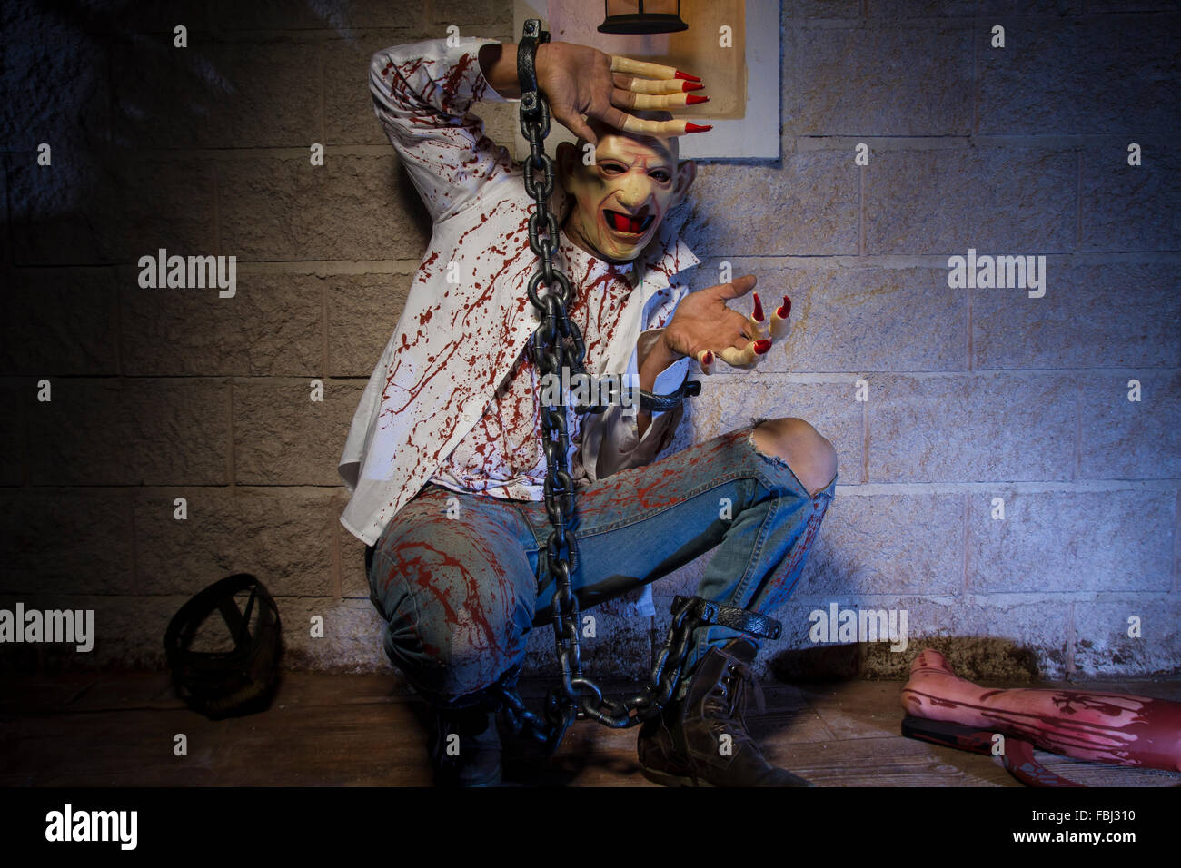 L'uomo incatenato con il sangue e il coltello, ha una gamba rotta sangue Foto Stock