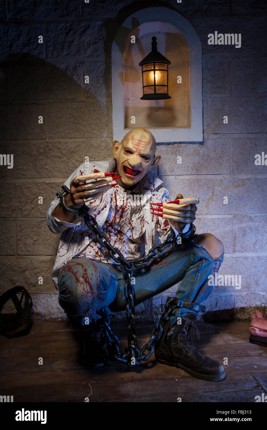 L'uomo incatenato con il sangue e il coltello, ha una gamba rotta sangue Foto Stock