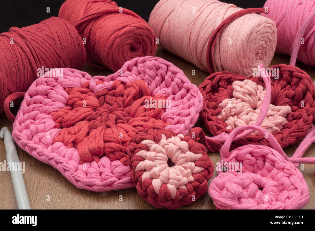 Un piano orizzontale di vista frontale del processo di creazione di qualche giorno di san valentino decorazioni a crochet e alcuni membri del personale necessario Foto Stock