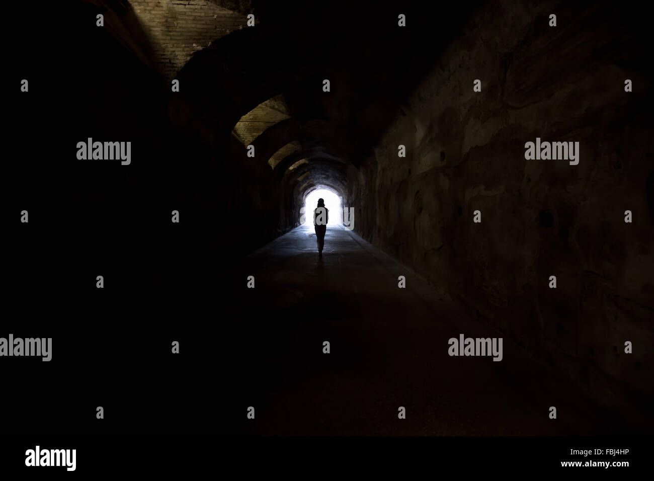 Persona nel buio del tunnel, andando verso la luce. La speranza, paura, "aldilà" concetti Foto Stock