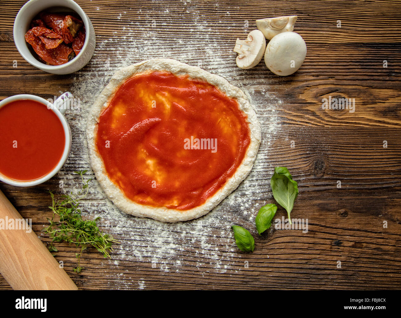 Impasto per pizza su tavola in legno rustico Foto Stock