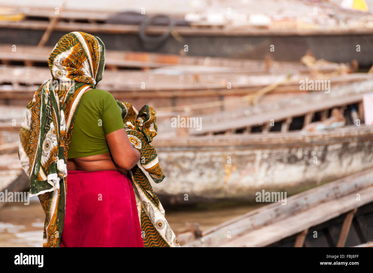 Donna indiana di vestirsi di sari dopo i religiosi bagno nel fiume Gange Foto Stock