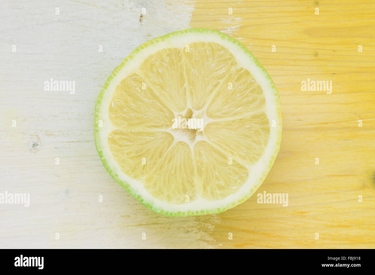 Fetta di limone su giallo-blu di sfondo Foto Stock