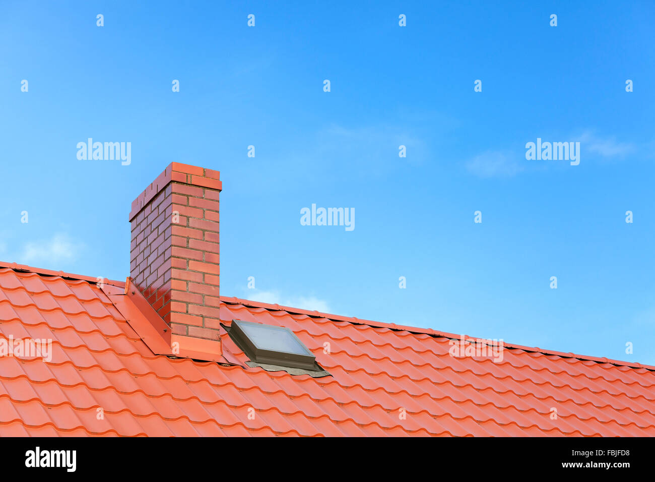 Tetto con piastrelle di ceramica camino contro il cielo blu, spazio per il testo. Foto Stock