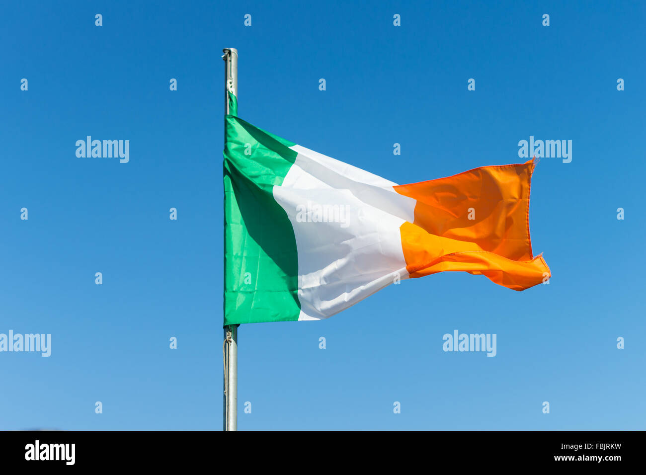 Teh Irish tricolore sventola su bianco in pole nella contea di Armagh, Irlanda. La bandiera nazionale dell'Irlanda. Verde, Bianco e arancione. Foto Stock