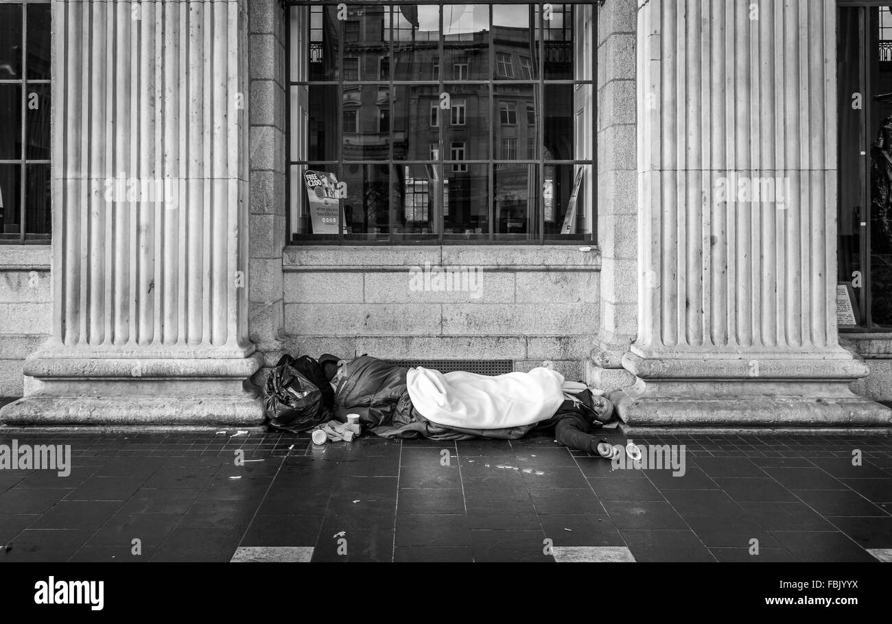 Due senzatetto uomini laici al di fuori dell'Ufficio Generale delle Poste GPO in Dublino è O'Connell Street. Foto Stock
