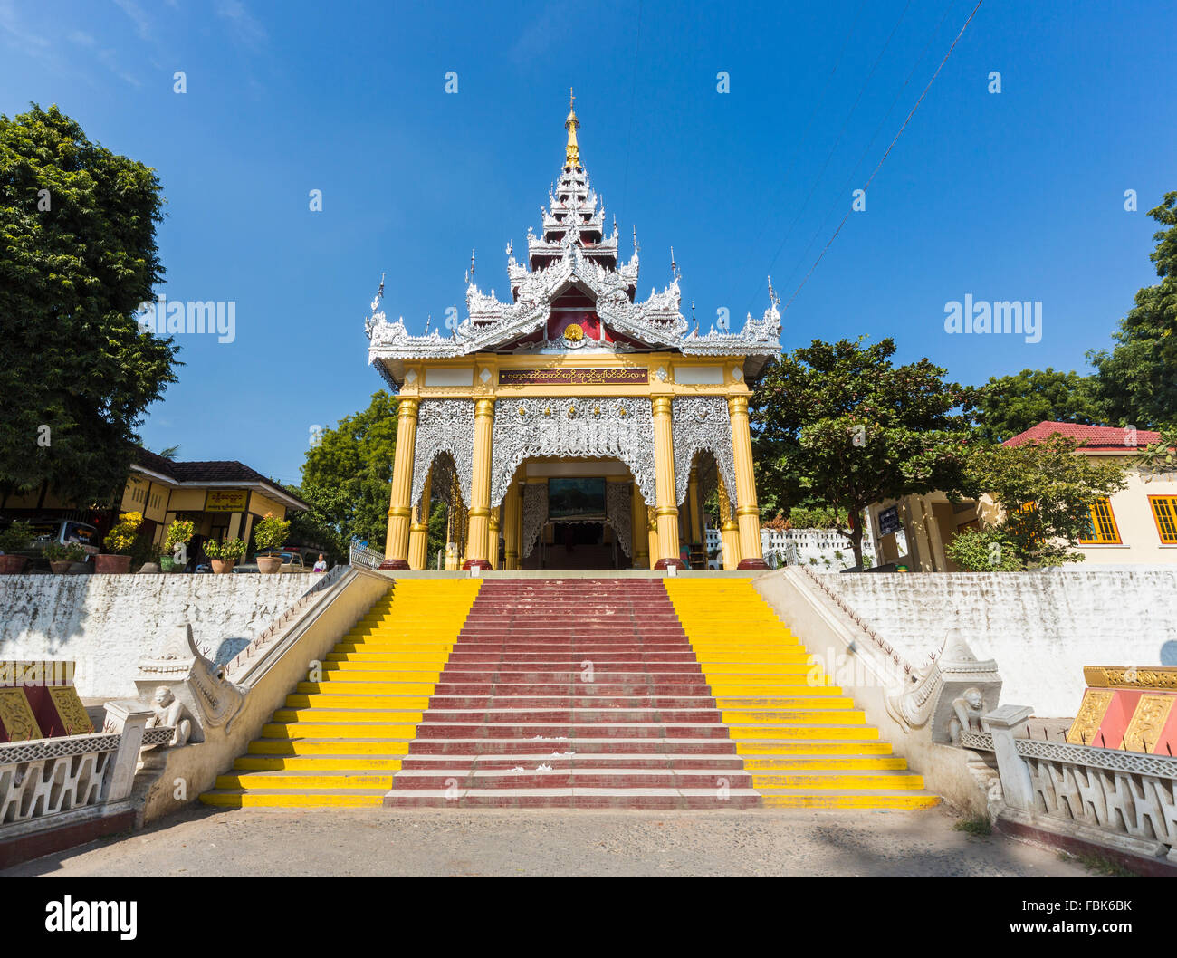 Ornati, stile tradizionale ingresso sud alla base del Mandalay Hill pagoda, Mandalay Myanmar (Birmania) nella luce del sole sotto un limpido cielo blu chiaro Foto Stock
