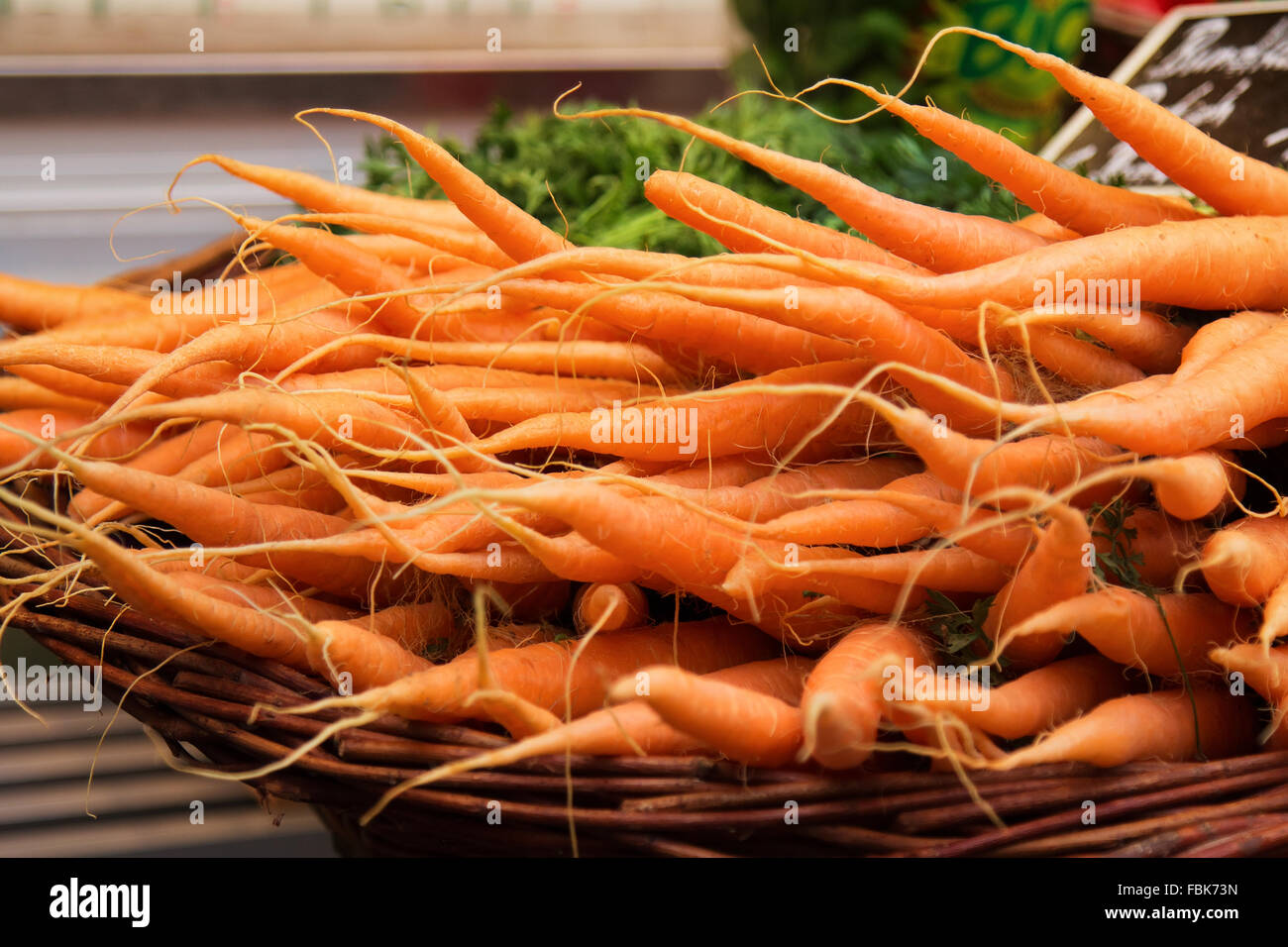 Le carote colorate in un cesto al mercato. Foto Stock