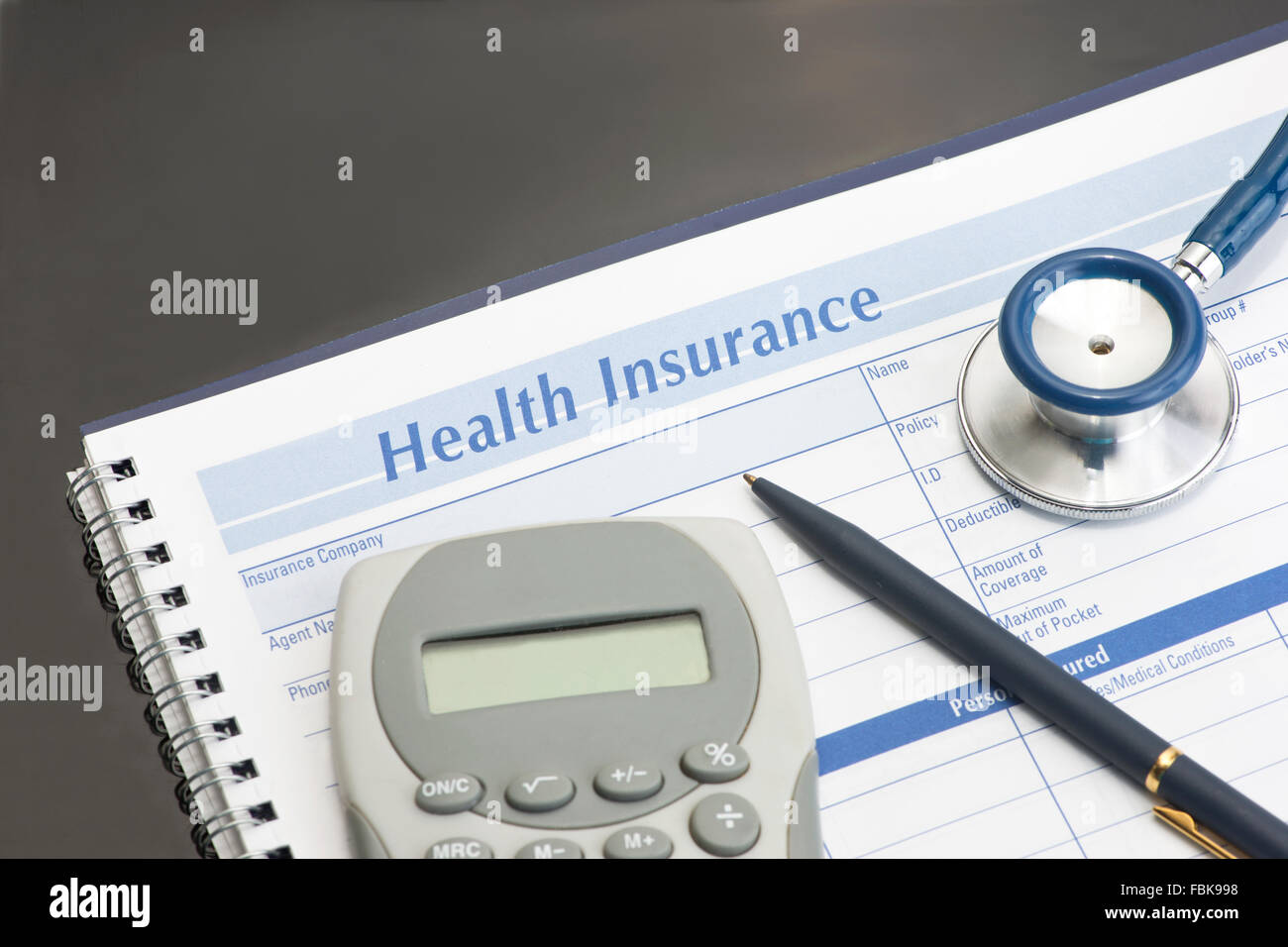 Assicurazione sanitaria record di spese con penna e calcolatrice su nero. Foto Stock