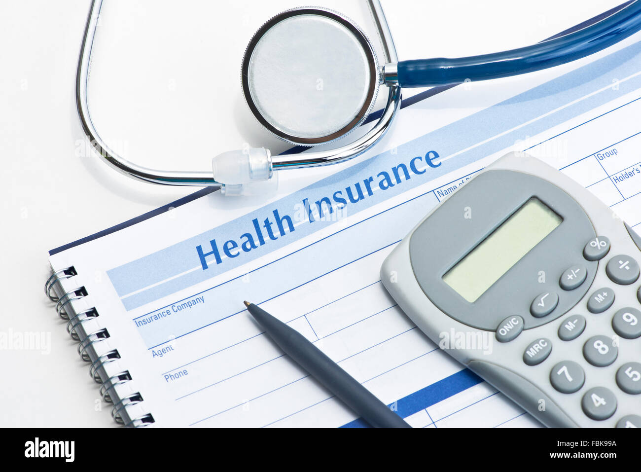 Assicurazione sanitaria record di spese con penna e calcolatrice su bianco. Foto Stock