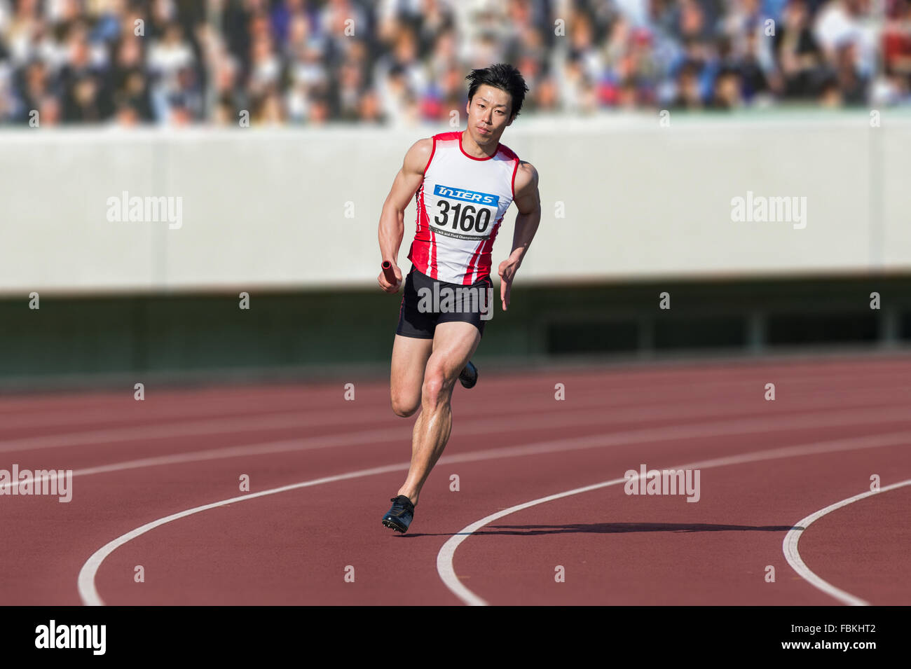 Maschio giapponese sprinter in esecuzione su via Foto Stock