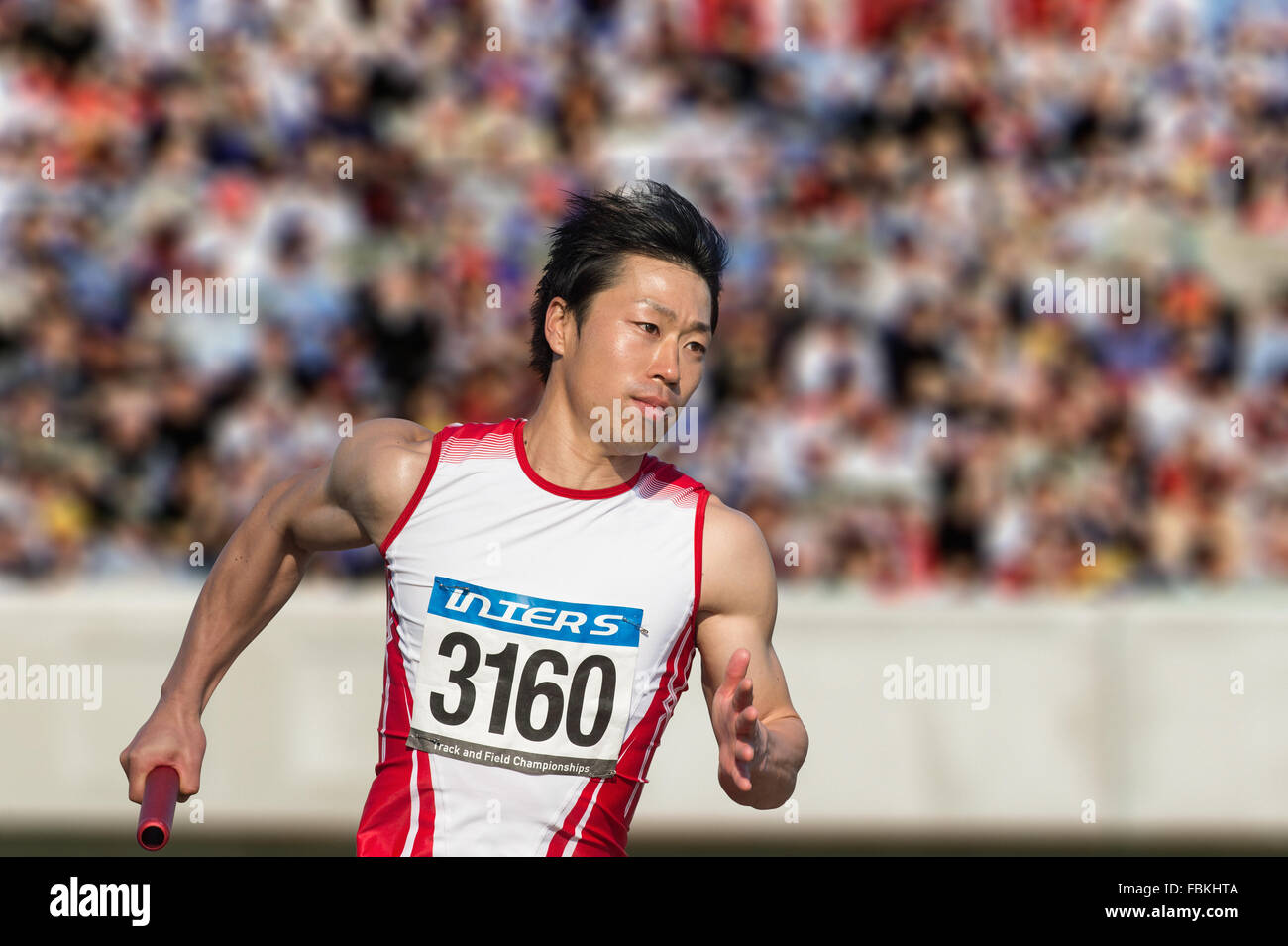 Maschio giapponese sprinter in esecuzione su via Foto Stock
