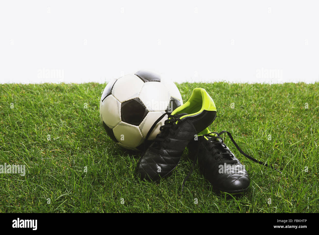 Pallone da calcio e scarpe di erba Foto Stock