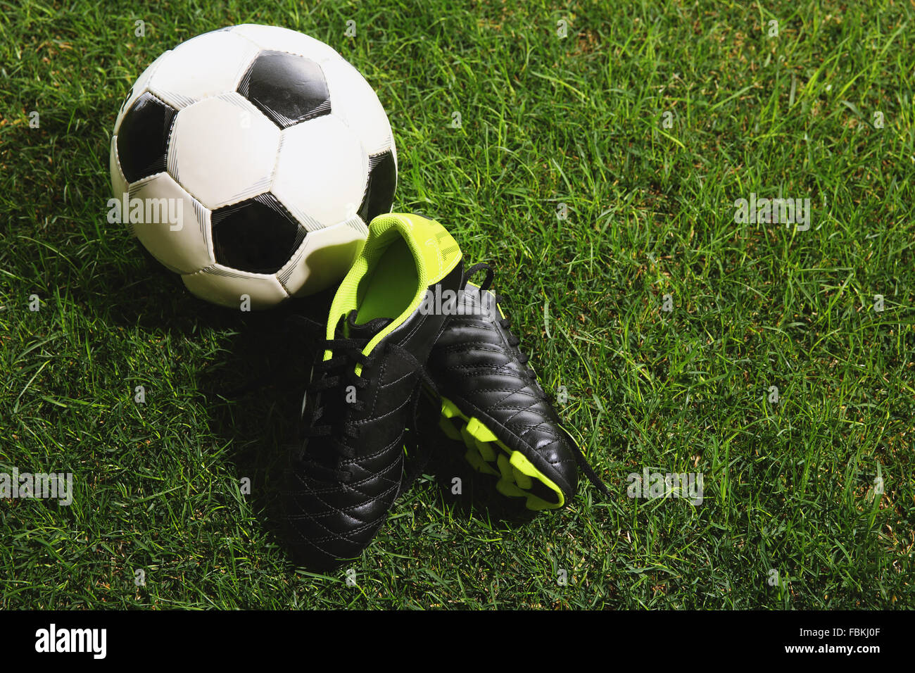 Pallone da calcio e scarpe di erba Foto Stock