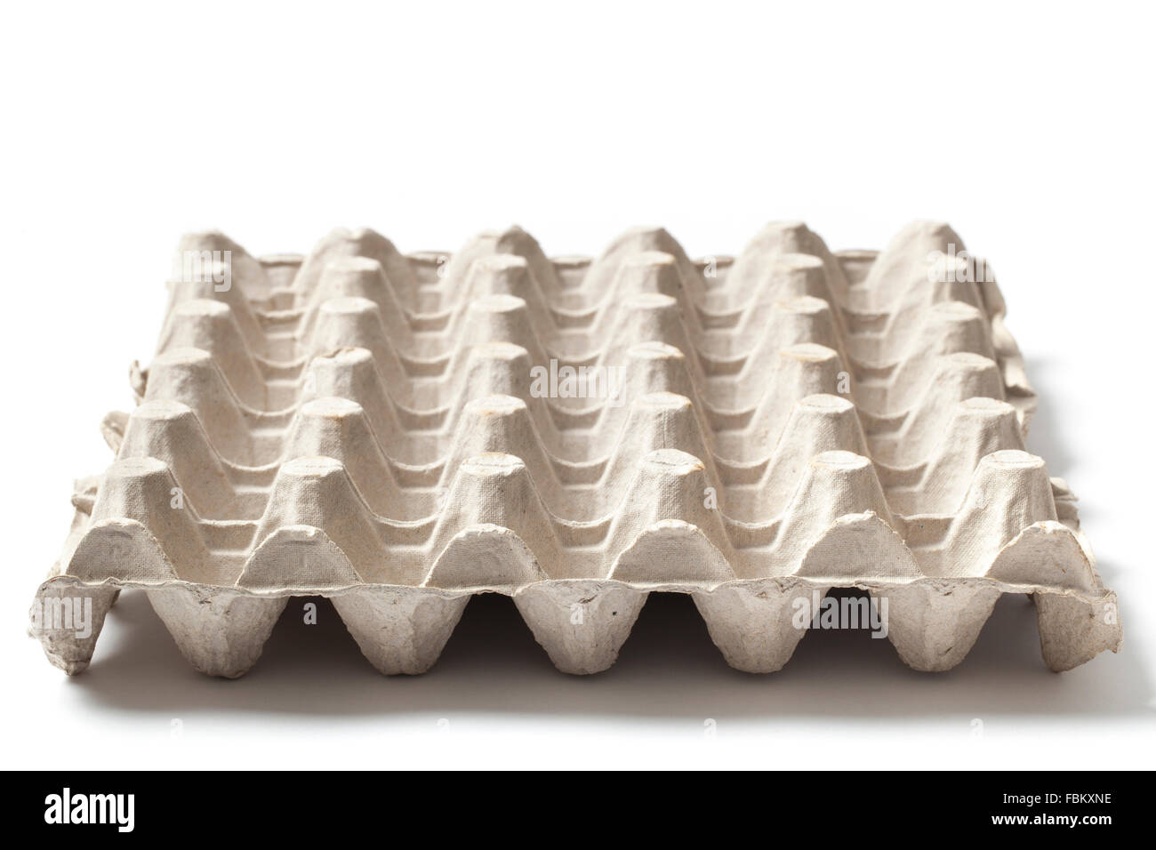 Svuotare le uova di carta il vassoio su un tavolo isolato su sfondo bianco. Foto Stock