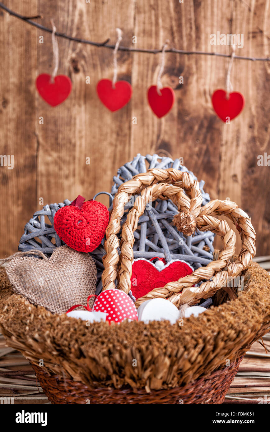 Molti cuori all'interno di un vecchio cesto in legno Foto Stock