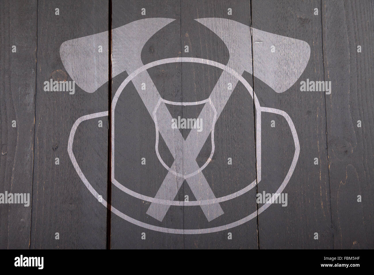 Illustrazione di fuoco segno uomo con casco e assi su nero scuro dello sfondo in legno Foto Stock