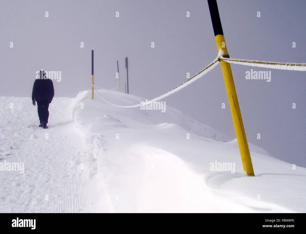 Vista frontale di uomo a camminare nella neve, Monte Titlis, Uri Alpi, Berna, Svizzera Foto Stock