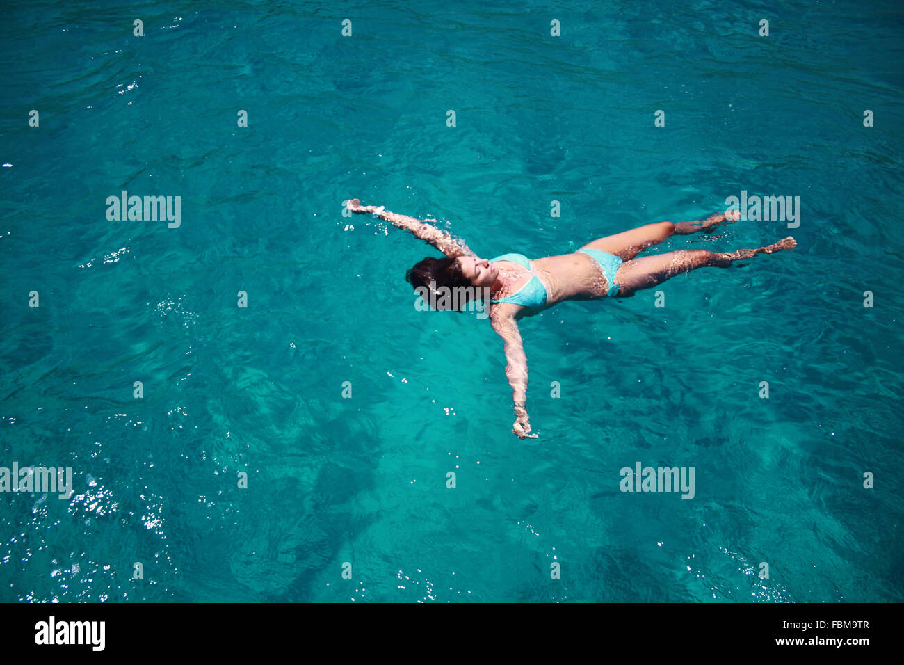 Vista panoramica di una donna che galleggia in mare, Porto Cervo, Olbia-Tempio, Sardegna, Italia Foto Stock