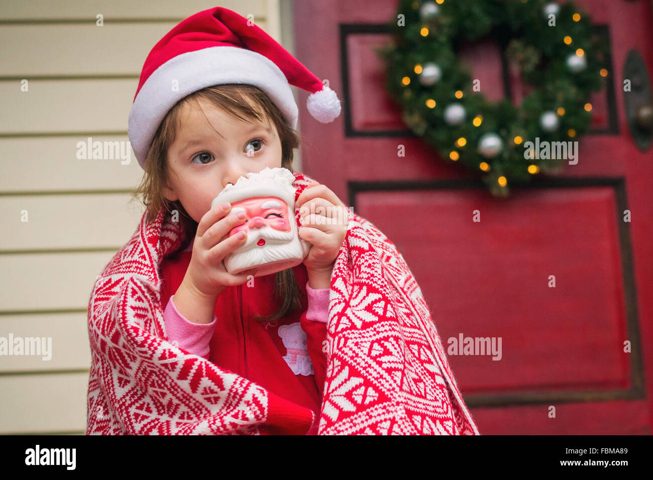 Ragazza seduta sui gradini di bere cioccolata calda in Santa cup Foto Stock
